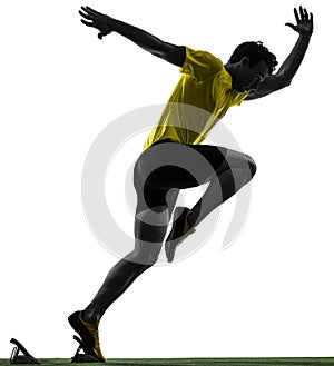 Young man sprinter runner in starting blocks silhouette