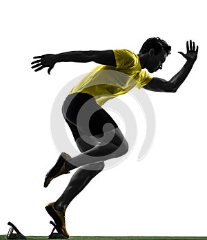 Young man sprinter runner in starting blocks silhouette