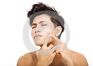 young man Squeezing pimple photo