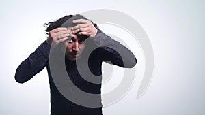 Young man squeezing a pimple on white background