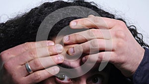 Young man squeezing a pimple on white background. close up