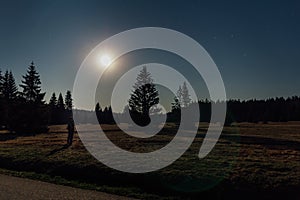 Young man stand in nice star night with trees and moon in Novohradske hory, Czech landscape