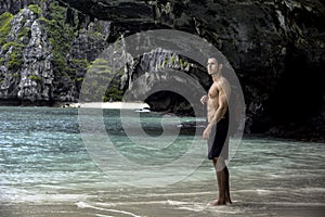 Young man standing on beach by the ocean