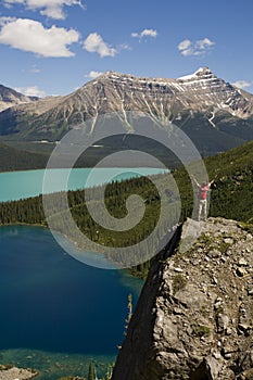 Young man standing on boulder above lakes