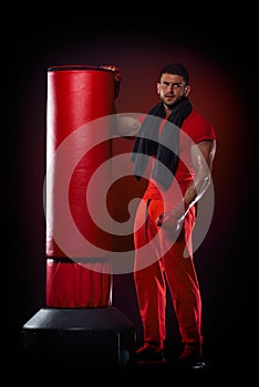Young man standing by boxing bag