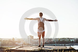 Young man standing on the cliff with a city view