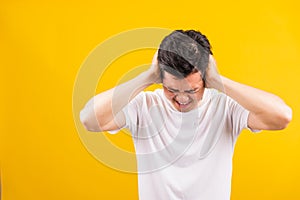 Young man standing he covering his ears with hands and shouting opened mouth shriek photo
