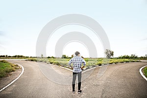 Young man standing at crossroads. Concept of choice