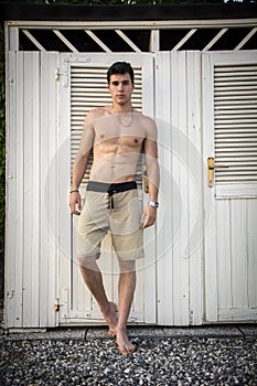 Young Man Standing in Doorway of Rustic Beach Hut