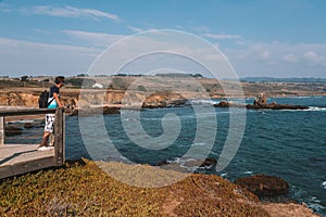 Young man standing on the edge of the pier by the Californian