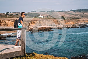 Young man standing on the edge of the pier by the Californian