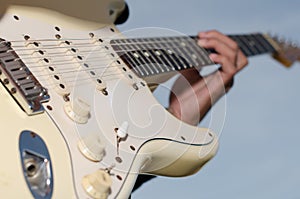 A young man standing guitarist happily under the blue sky in th