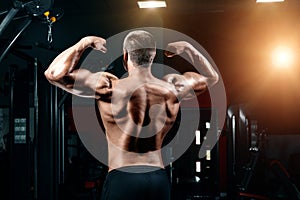 Young Man Standing Strong In The Gym And Flexing Muscles - Muscular Athletic Bodybuilder Fitness Model Posing After Exercises