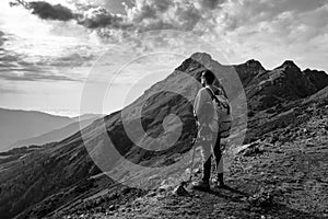 Young man standing on top of cliff mountains