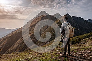 Young man standing on top of cliff mountains