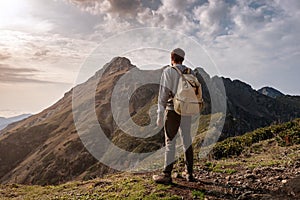 Young man standing on top of cliff mountains