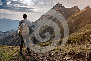 Young man standing on top of cliff mountains