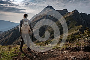 Young man standing on top of cliff mountains