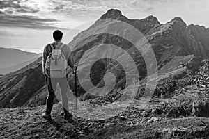 Young man standing on top of cliff mountains