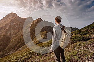 Young man standing on top of cliff mountains