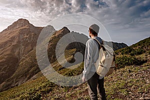 Young man standing on top of cliff mountains