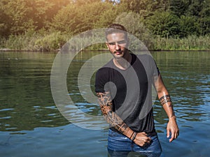 Young man standing in water in sea or lake