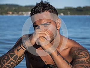 Young man standing in water in sea or lake