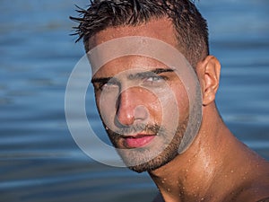 Young man standing in water in sea or lake