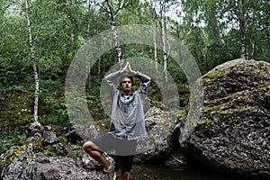 Young man stands in the forest.