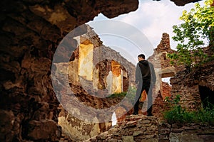 Young man stands in old ruined castle, Halshany, Belarus