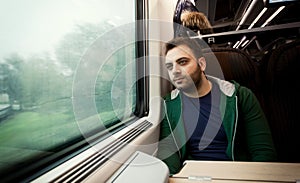 Young man staring out the train window.