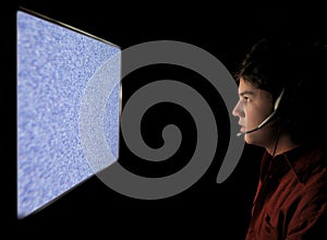 Young man staring into static TV Computer screen