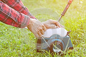 Young man starting the petrol lawnmower