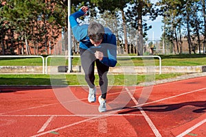 Young Man Starting sprint on Running Track.