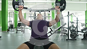 Young man starting to flexing chest muscles on gym machine