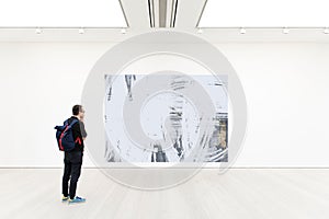 Young man staying at the art gallery. He is watching the art object. Free your creativity! Copy space. Template.