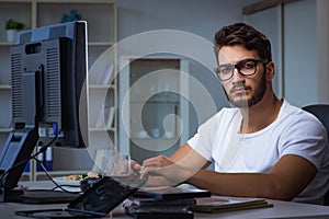 The young man staying late in office to do overtime work