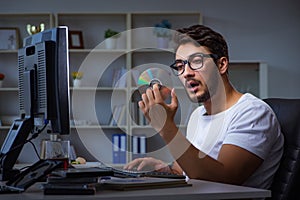 The young man staying late in office to do overtime work