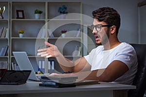 The young man staying late in office to do overtime work