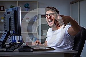 The young man staying late in office to do overtime work