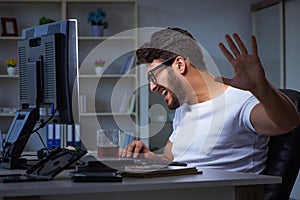 The young man staying late in office to do overtime work