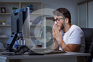 The young man staying late in office to do overtime work