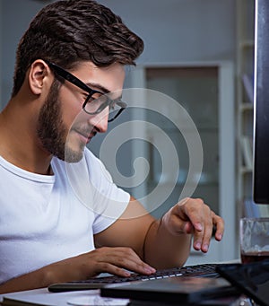 Young man staying late in office to do overtime work