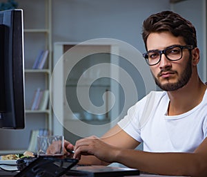 Young man staying late in office to do overtime work