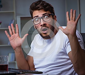 Young man staying late in office to do overtime work