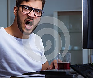 Young man staying late in office to do overtime work