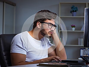 The young man staying late in office to do overtime work