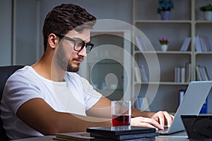 The young man staying late in office to do overtime work