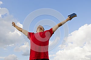 Young man staying with raised hands photo