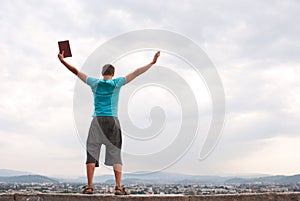 Young man staying with raised hands